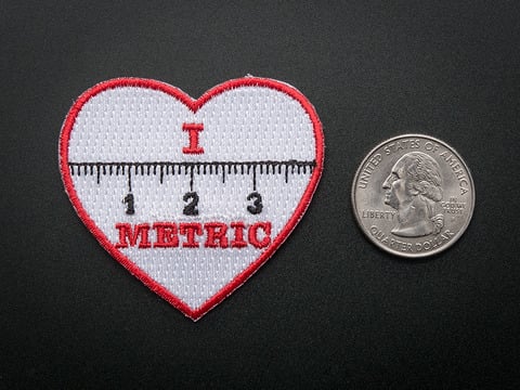 612 This is the "I heart metric" skill badge from Adafruit Industries LLC. It is an iron-on patch designed to reward beginners on their skill-building journey.